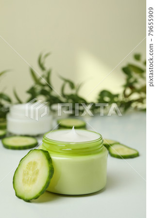 Jars with cosmetic cream, cucumber slices and branch on white table Jars with cosmetic cream, cucumber slices and branch on white table 79655909