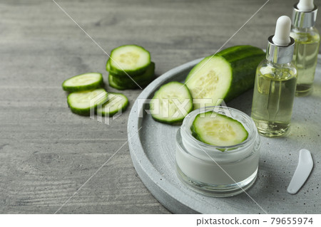 Cosmetics and cucumber on tray on gray textured background 79655974