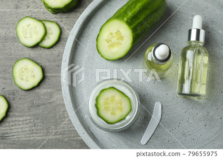 Cosmetics and cucumber on tray on gray textured background 79655975