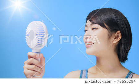 Female portable fan using a handy fan 79656294