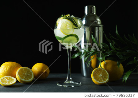 Glass of cocktail with citrus against dark background Glass of cocktail with citrus against dark background 79656337