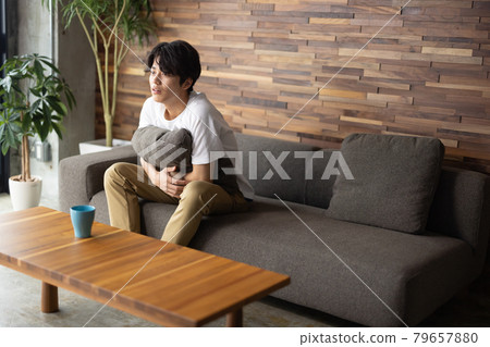 Young man watching tv in the living room 79657880