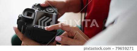 Two women hold camera in their hands Two women hold camera in their hands 79659271