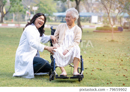 Doctor help and care Asian senior or elderly old lady woman patient sitting on wheelchair at park in nursing hospital ward; healthy strong medical concept 79659902
