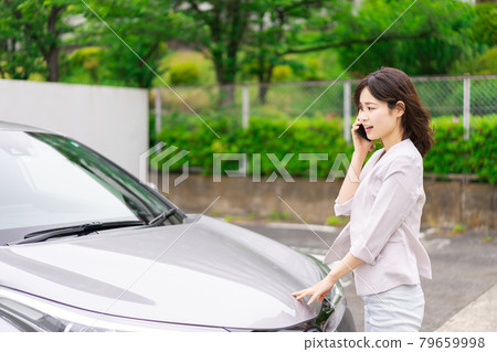 Young woman contacting when a car breaks down Young woman contacting when a car breaks down 79659998