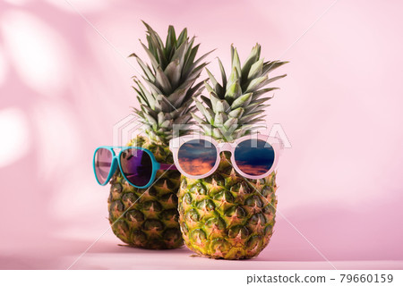 Fresh Ripe Pineapple wearing sunglasses against pink background. Hello, Summer or Summer Season Sale Concept. 79660159