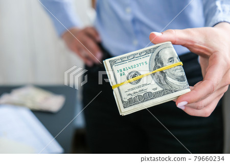 Business Woman Displaying a Spread of Cash US dollars. Close-up. Income and Business concept. Venality, bribe, corruption concept. Hand giving money. Millennial candid authentic female hands counting Business Woman Displaying a Spread of Cash US dollars. Close-up. Income and Business concept. Venality, bribe, corruption concept. Hand giving money. Millennial candid authentic female hands counting 79660234