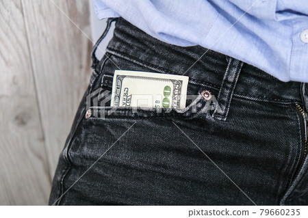 Close up hand of businesswoman holding banknote into pocket. Profitable investment. The exchange of currencies. Money to buy debt securities increase revenue. Hand puts dollar bills in the pocket 79660235