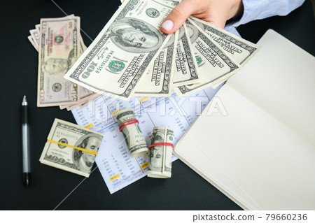 Business Woman Displaying a Spread of Cash US dollars. Close-up. Income and Business concept. Venality, bribe, corruption concept. Hand giving money. Millennial candid authentic female hands counting Business Woman Displaying a Spread of Cash US dollars. Close-up. Income and Business concept. Venality, bribe, corruption concept. Hand giving money. Millennial candid authentic female hands counting 79660236