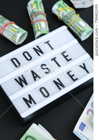 Lightbox board with word DONT WASTE MONEY in black letters around euro banknotes. Money, Business, finance, investment, saving Lightbox board with word DONT WASTE MONEY in black letters around euro banknotes. Money, Business, finance, investment, saving 79660249