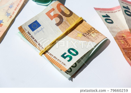 Close up of Euro money roll. Euro banknote set cash money - EU currency. Rolled with rubber euro notes. Banknotes stacked on each other in different positions Close up of Euro money roll. Euro banknote set cash money - EU currency. Rolled with rubber euro notes. Banknotes stacked on each other in different positions 79660259