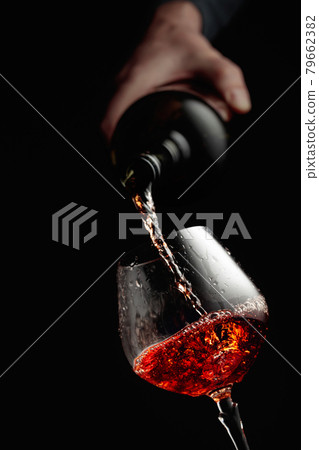 Pouring brandy in a glass goblet. 79662382