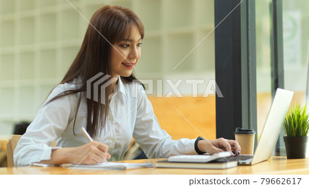 Business student doing lecture on online class via portable laptop at library, E-learning concept Business student doing lecture on online class via portable laptop at library, E-learning concept 79662617
