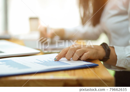 Cropped shot of female finger pointing on financial papers Cropped shot of female finger pointing on financial papers 79662635