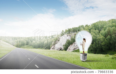 Businesswoman inside light bulb Businesswoman inside light bulb 79663336