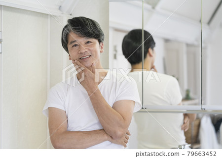站在洗手間鏡子前的中年男子 站在洗手間鏡子前的中年男子 79663452