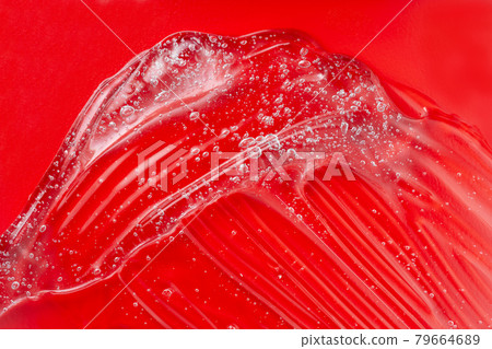 Cosmetic gel smudge with bubble. Transparent skincare product on red. Liquid lotion splash. Serum gel. Hyaluronic acid smear. Lubricant sample. Moisturiser with vitamin. Jelly texture.. 79664689