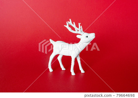 White festive reindeer on red background. Decoration deer toy. Christmas minimal concept, front view White festive reindeer on red background. Decoration deer toy. Christmas minimal concept, front view 79664698