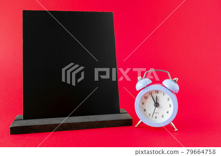 Wooden chalkboard mockup or wooden frame, alarm clock 12 hours on red surface. Dark information board template, sign board for menu in cafe, restaurant or shop. Time for lunch or dinner. Wooden chalkboard mockup or wooden frame, alarm clock 12 hours on red surface. Dark information board template, sign board for menu in cafe, restaurant or shop. Time for lunch or dinner. 79664758