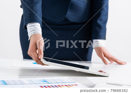 Businesswoman standing near office desk Businesswoman standing near office desk 79666382