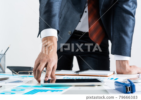 Businessman standing near office desk Businessman standing near office desk 79666383