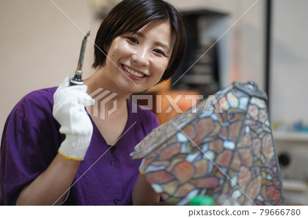 Woman making stained glass lamps Woman making stained glass lamps 79666780