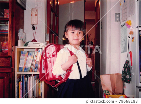 Old film photo: A girl in the first grade of elementary school carrying a new school bag Old film photo: A girl in the first grade of elementary school carrying a new school bag 79668188