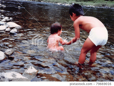 男孩和女孩在河裡玩耍的老電影照片 79669016