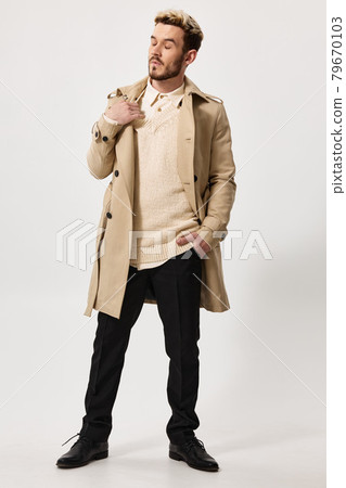 a man in a first coat and a sweater, do not touch his shoulder and look to the side hand in his pocket 79670103