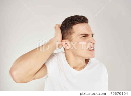 emotional man in white t-shirt emotions studio light background emotional man in white t-shirt emotions studio light background 79670104