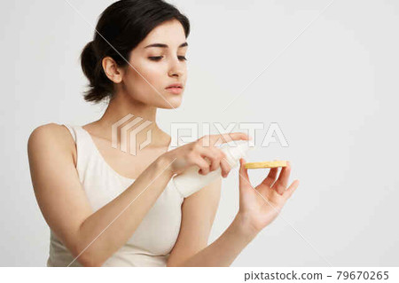 pretty brunette in a white tank top sponge in hands clean skin face care pretty brunette in a white tank top sponge in hands clean skin face care 79670265