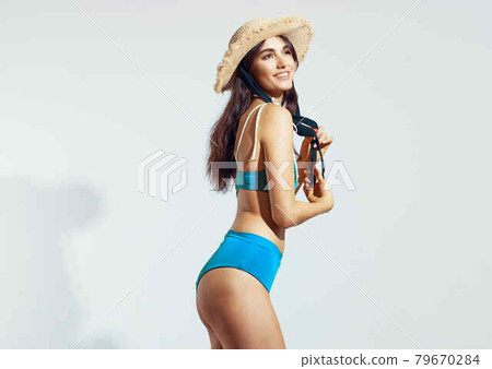 pretty woman in blue swimsuit beach hat summer lifestyle light background 79670284