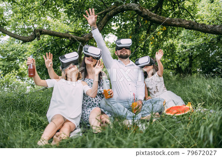 Happy family having fun in virtual glasses on fresh air 79672027