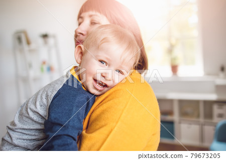 Happy mother embracing her smiling son carefully Happy mother embracing her smiling son carefully 79673205