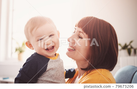 Happy mother holding in her arms her smiling son. Happy mother holding in her arms her smiling son. 79673206