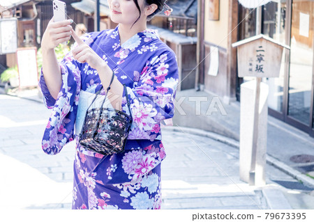A woman sightseeing in Kyoto in a yukata A woman sightseeing in Kyoto in a yukata 79673395