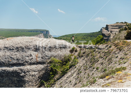 beautiful brunette woman on a cliff looking at the nature of the journey beautiful brunette woman on a cliff looking at the nature of the journey 79673701
