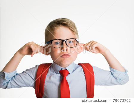 Funny smart kid boy in school uniform pulling ears and showing tongue isolated on white background. Student making monkey face. Funny silly child boy grimacing Funny smart kid boy in school uniform pulling ears and showing tongue isolated on white background. Student making monkey face. Funny silly child boy grimacing 79673702