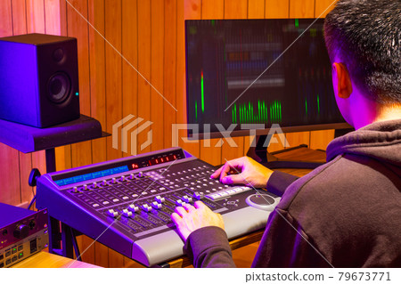 back of asian professional sound engineer mixing audio signal on control surface mixing console in broadcasting, recording studio back of asian professional sound engineer mixing audio signal on control surface mixing console in broadcasting, recording studio 79673771