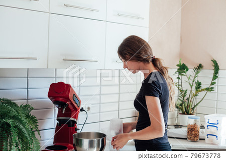 a woman cooks sweet cakes in the kitchen a woman cooks sweet cakes in the kitchen 79673778