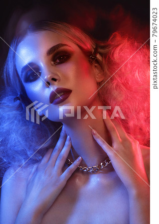 Portrait of a beautiful woman with bright evening makeup and colored filters. 79674023