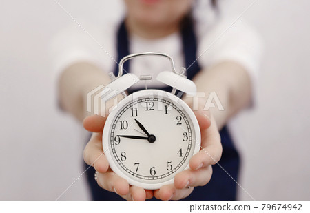 woman hands holding white alarm clock closeup photo woman hands holding white alarm clock closeup photo 79674942