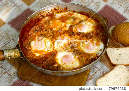 shakshuka - jewish national dish with fried eggs species, tomato, pepper garlic shakshuka - jewish national dish with fried eggs species, tomato, pepper garlic 79674988