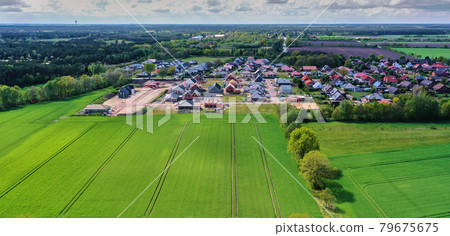 Aerial view of a development area with carcasses for single-family houses at the edge of a green field Aerial view of a development area with carcasses for single-family houses at the edge of a green field 79675675