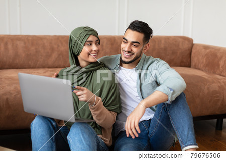 Happy man and woman using laptop after relocation 79676506