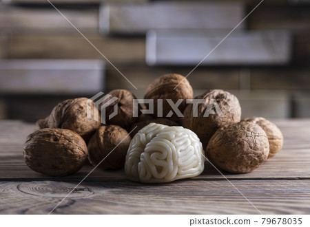 Walnuts like healthy food for the brain. Shape of human brain is surrounded by walnut kernels. It symbolizes how brain similarity with walnuts and proven effectiveness as healthy food for brain. 79678035