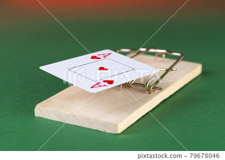 Playing card and mousetrap, game trap, on a green background, get into gambling addiction Playing card and mousetrap, game trap, on a green background, get into gambling addiction 79678046