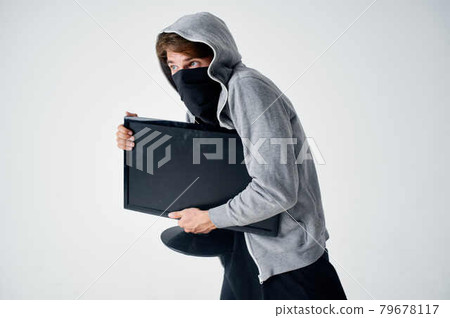 a man with a hood in a mask steals a tech computer 79678117