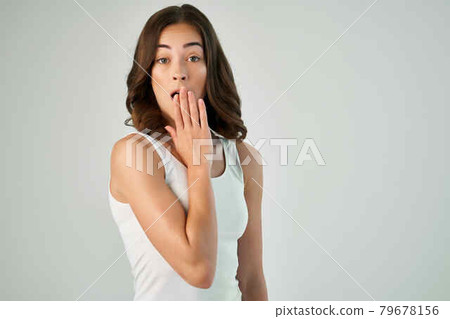 cheerful brunette in a white T-shirt and holding her hair in casual clothes 79678156