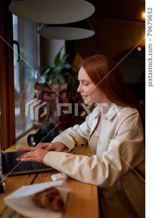 Hipster woman traveler using laptop computer in cafe, working at coffee shop. Hipster woman traveler using laptop computer in cafe, working at coffee shop. 79679652